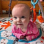 baby, infant, pink_clothing, play_mat, toy, animal_design, blue, orange, cute, happy, face, child, indoor, wooden_furniture, smiling, colorful, toddler, crawling, playtime, closeup