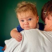 Miles is registered to the contest to win money with this photo: accessories, baby, blanket, bodypart, clothing, face, finger, frown, glasses, hand, happy, head, hugging, newborn, person, photography, portrait, sad, smile, t_shirt