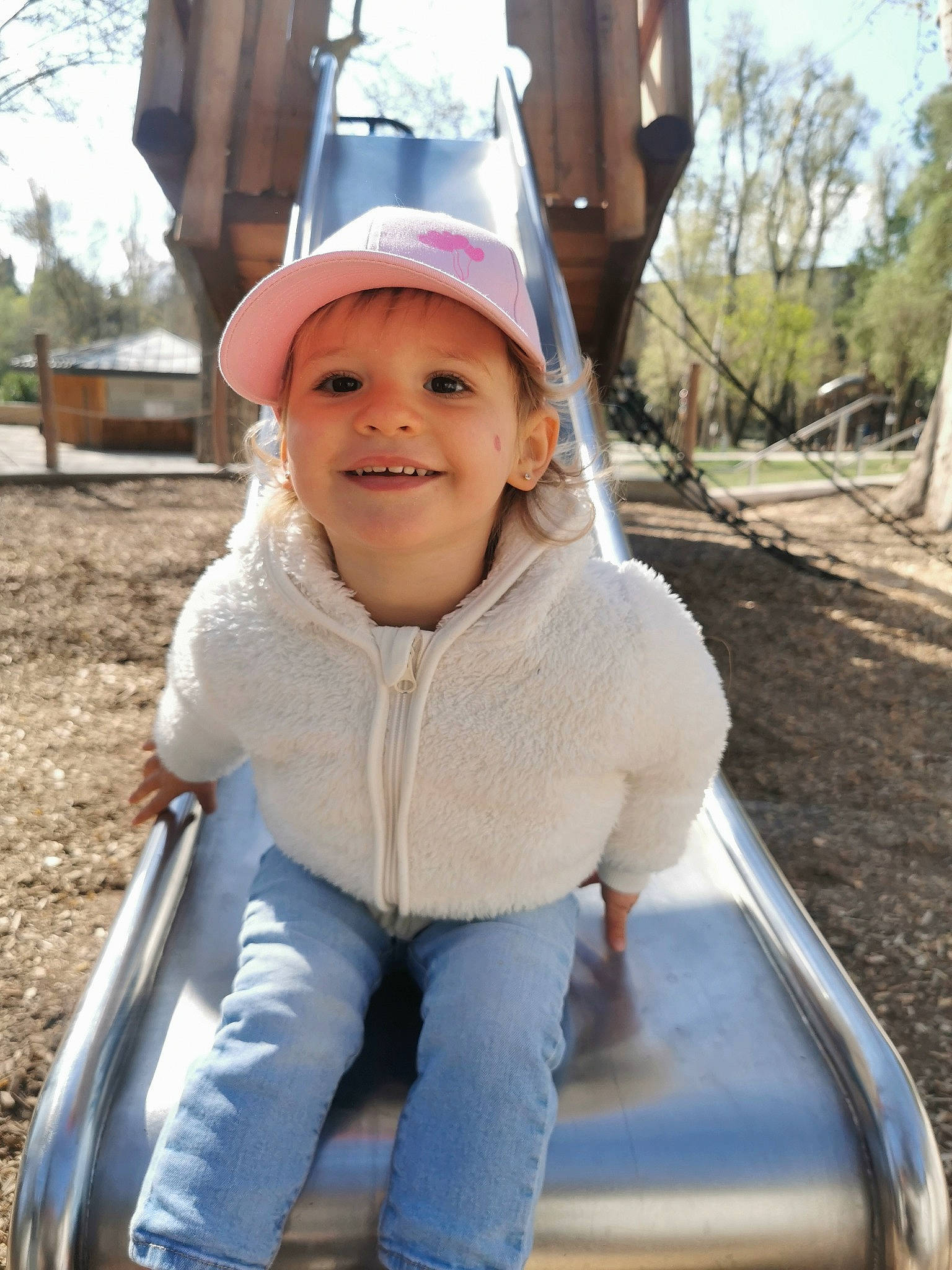 Elisa participe au concours pour gagner de l'argent avec cette photo : baseball_cap, cap, child, electric_blue, fun, grass, happy, hat, headwear, joy, leisure, outdoor_play_equipment, person, plant, playground, public_space, recreation, skin, sky, smile