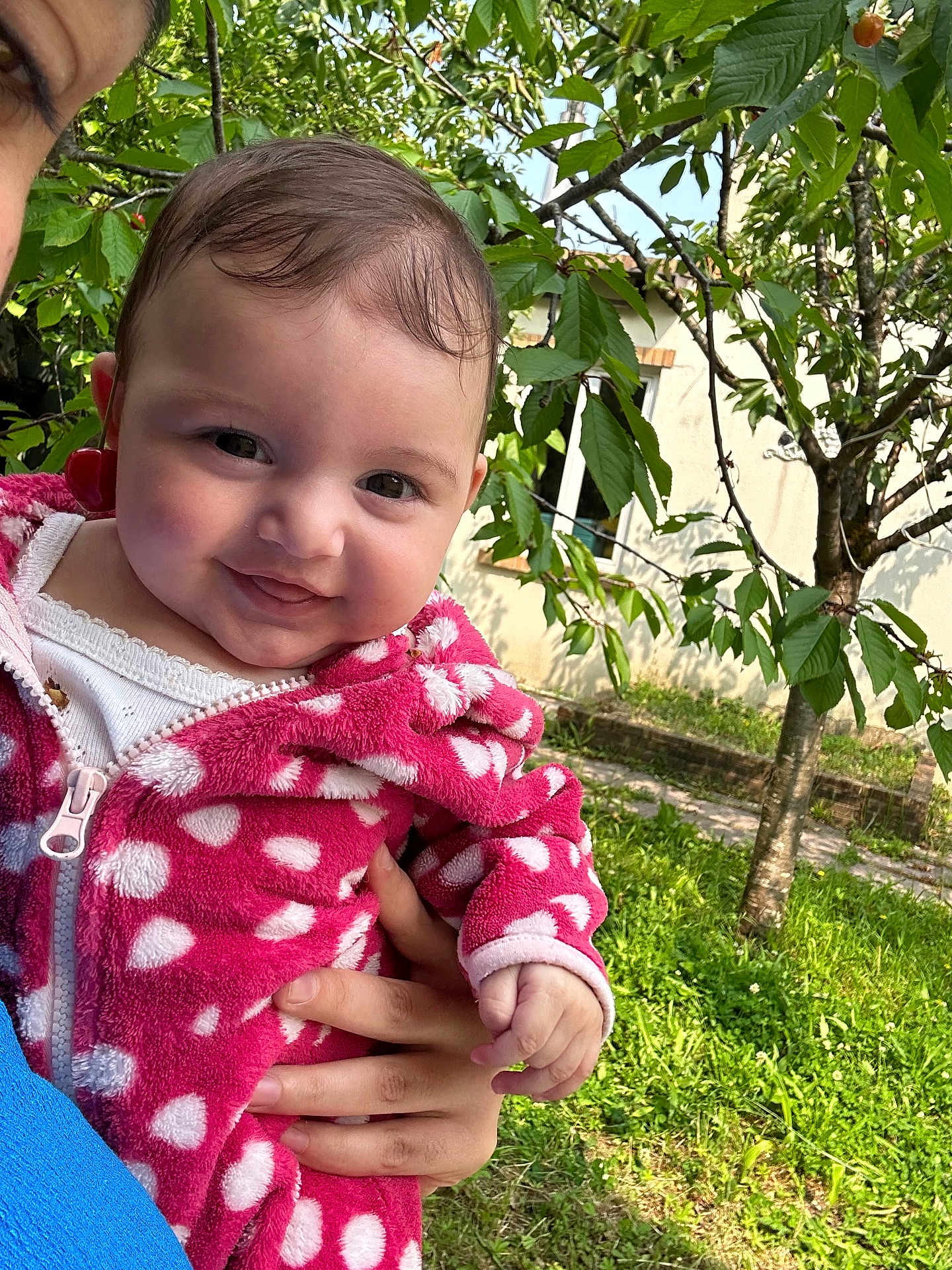 Aleda a rejoint le concours — aidez-le/la à gagner de superbes lots ! baby, child, cute, daylight, face, grass, greenery, hand, holding, house, jacket, nature, outdoor, person, pink, polka_dot, portrait, smile, tree, window
