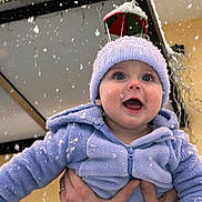 Lucian participe au concours pour gagner de l'argent avec cette photo : baby, child, snow, winter, outdoor, hat, blue_clothing, hands, smiling, face, snowflakes, joy, festive, decoration, cold_weather, cute, portrait, person, warm_clothing, hooded_jacket