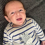 Maël participe au concours pour gagner de l'argent avec cette photo : baby, smiling, infant, striped_clothing, onesie, zebra_print, happy, face, person, cute, lying_down, hand, texture, blanket, indoor, closeup, newborn, child, expression, soft_fabric