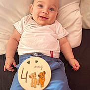 Kenzo a rejoint le concours — aidez-le/la à gagner de superbes lots ! baby, bed, blue_pants, cartoon_lions, child, cute, cuteness, hand, happy, indoors, infant, lying_down, milestone_sign, person, pillow, portrait, skin, smiling, white_shirt, young_child