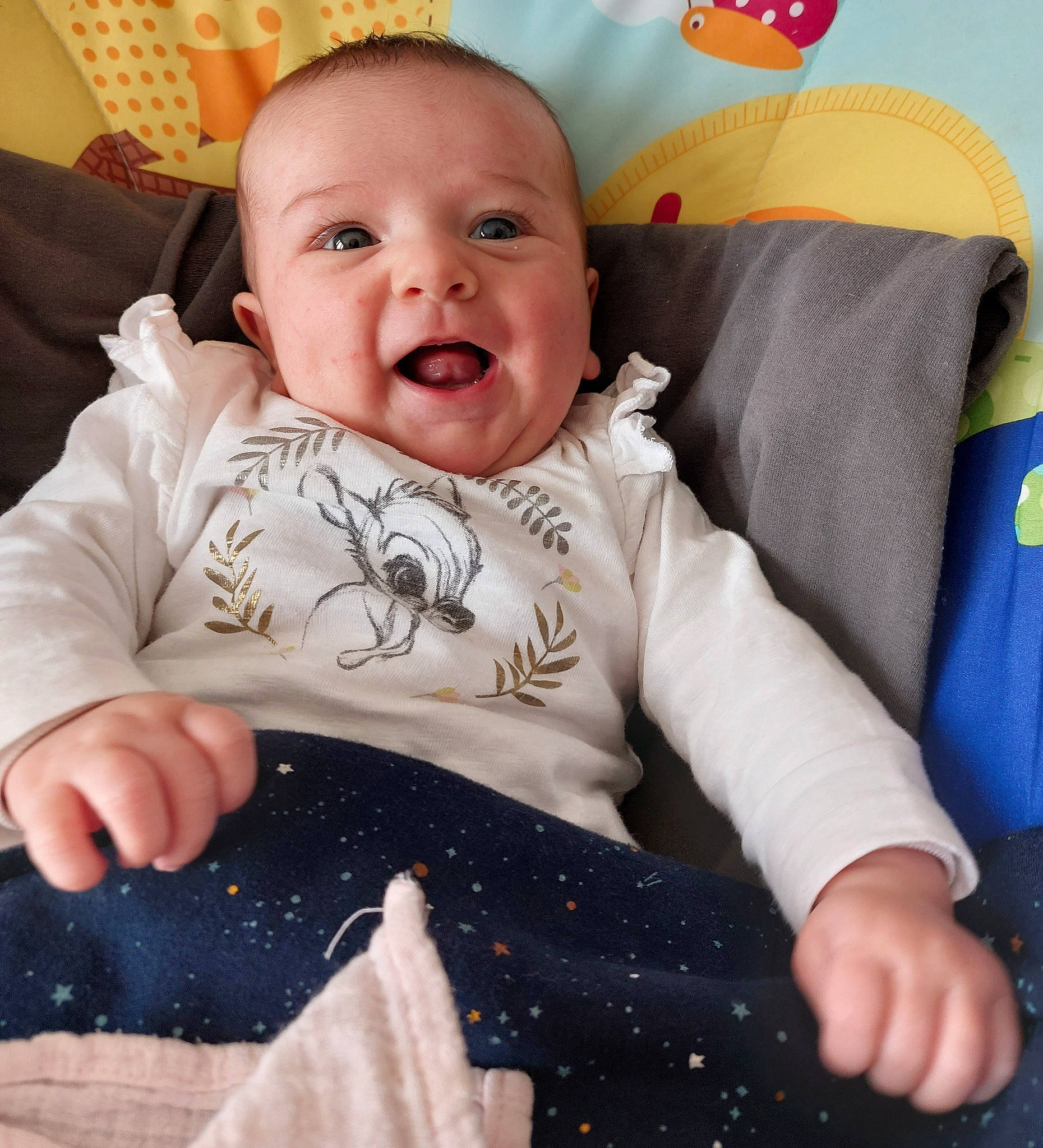 Ellie participe au concours pour gagner de l'argent avec cette photo : baby, baby_products, baby_toddler_clothing, bedding, cheek, child, comfort, electric_blue, fun, happy, laugh, linens, pattern, person, sitting, skin, sleeve, smile, t_shirt, textile