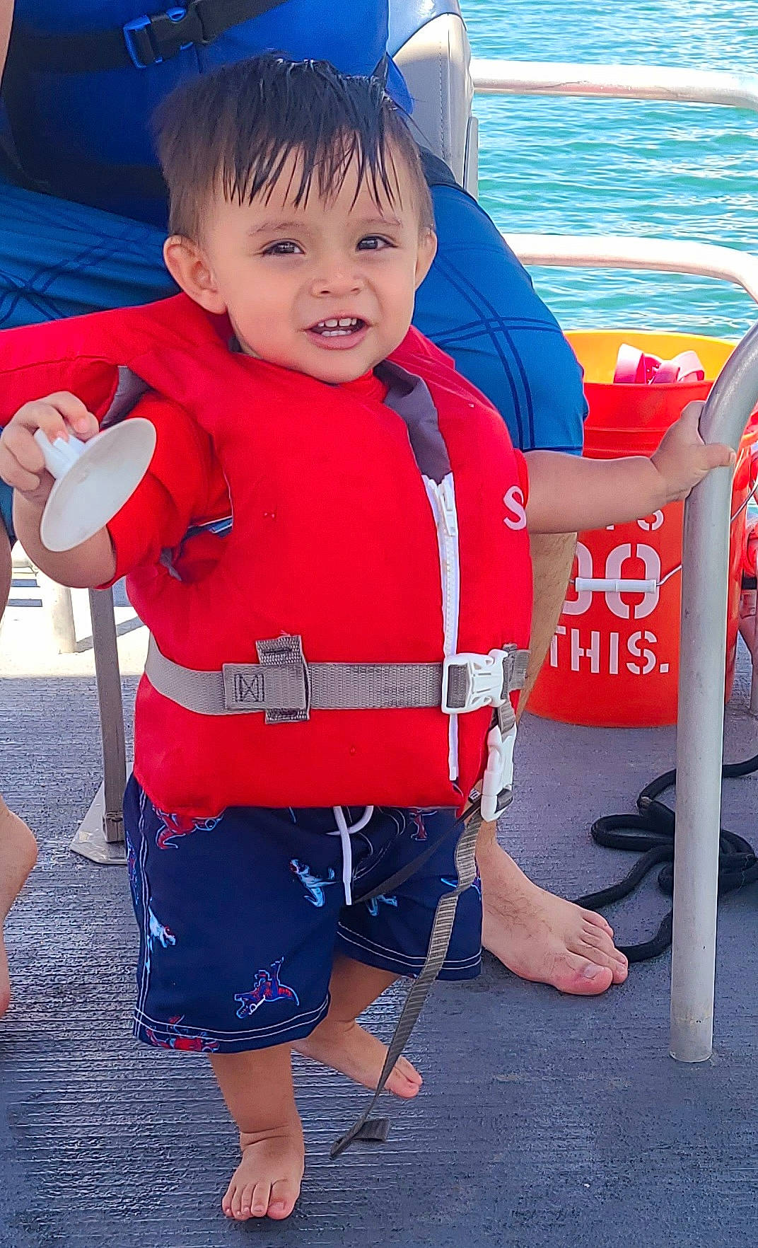 Dominik is registered to the contest to win money with this photo: baby_toddler_clothing, blue, chair, child, electric_blue, fun, happy, human_leg, leg, leisure, lifejacket, person, personal_protective_equipment, photograph, sitting, sleeve, smile, snapshot, toddler, water