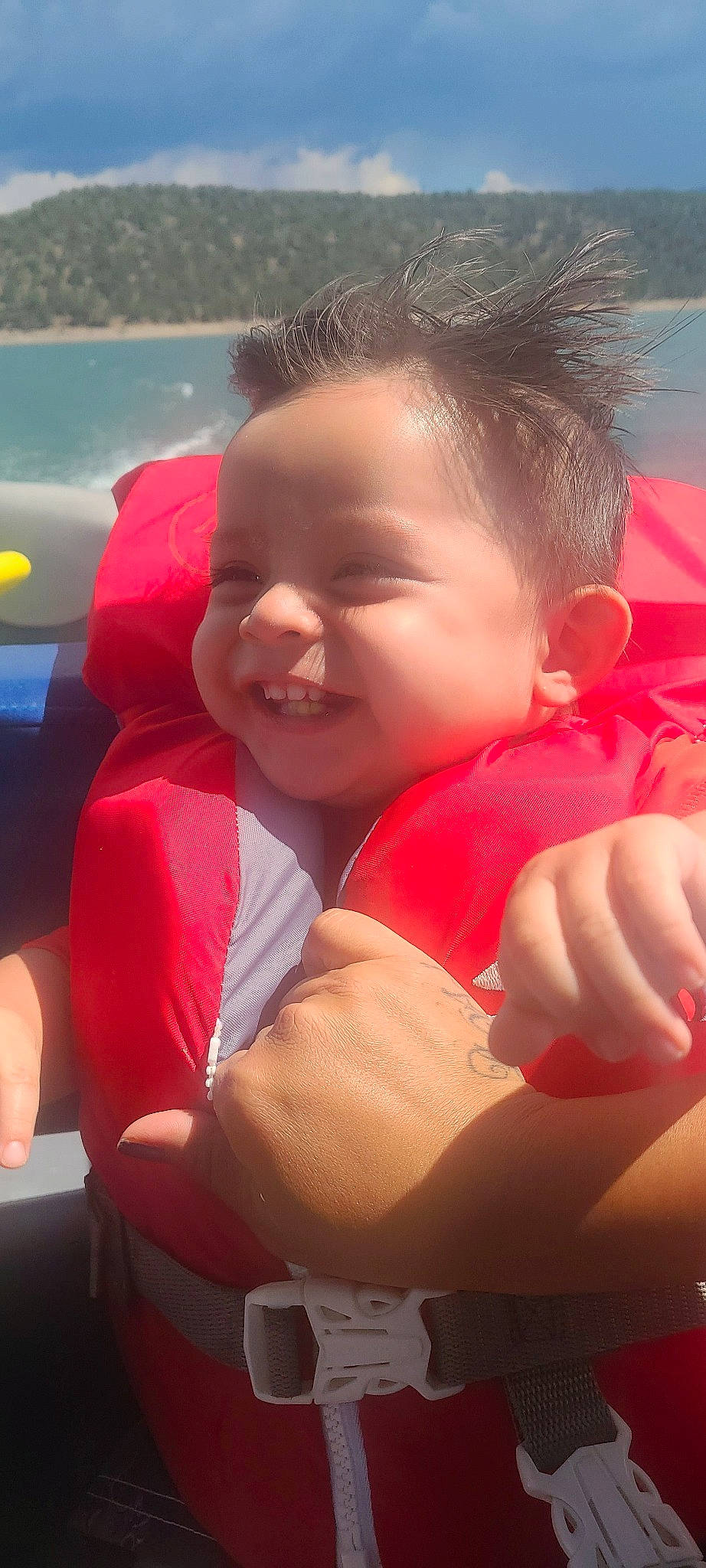 Dominik is registered to the contest to win money with this photo: baby, chest, child, cloud, cool, facial_expression, finger, fun, gesture, happy, leisure, lifejacket, mammal, mouth, nose, person, recreation, skin, smile, thumb