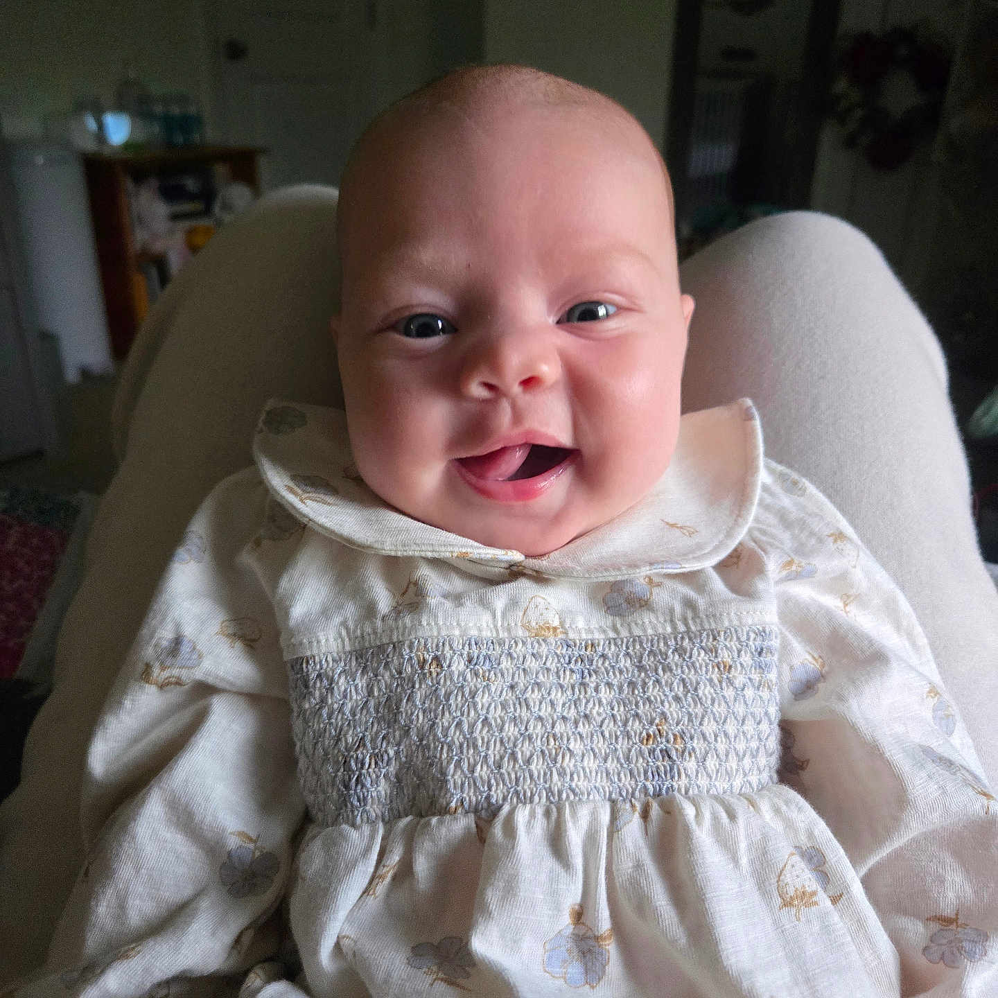 Remington is registered to the contest to win money with this photo: baby, infant, smile, face, person, clothing, sitting, happy, portrait, indoors, lap, cute, child, young, light, fabric, pattern, home, comfort, expression