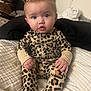 Xiomara joined the competition — help win amazing prizes! baby, bedroom, blanket, child, cozy, curious, cute, expression, face, hair_clip, hands, indoor, infant, leopard_print, onesie, portrait, quilt, sitting, soft_lighting, young_child