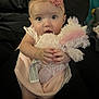 Xiomara is registered to the contest to win money with this photo: apparel, baby, child, cute, fabric, flower, hands, headband, indoors, infant, person, pink_dress, plush_toy, portrait, sitting, soft_toy, surprised, toy, unicorn, wide_eyes