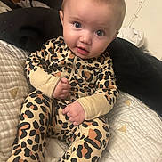 Xiomara joined the competition — help win amazing prizes! baby, blanket, bow, child, clothing, comfortable, cozy, cute, expression, face, headwear, indoor, infant, leopard_print, onesie, person, portrait, sitting, soft_texture, young_child