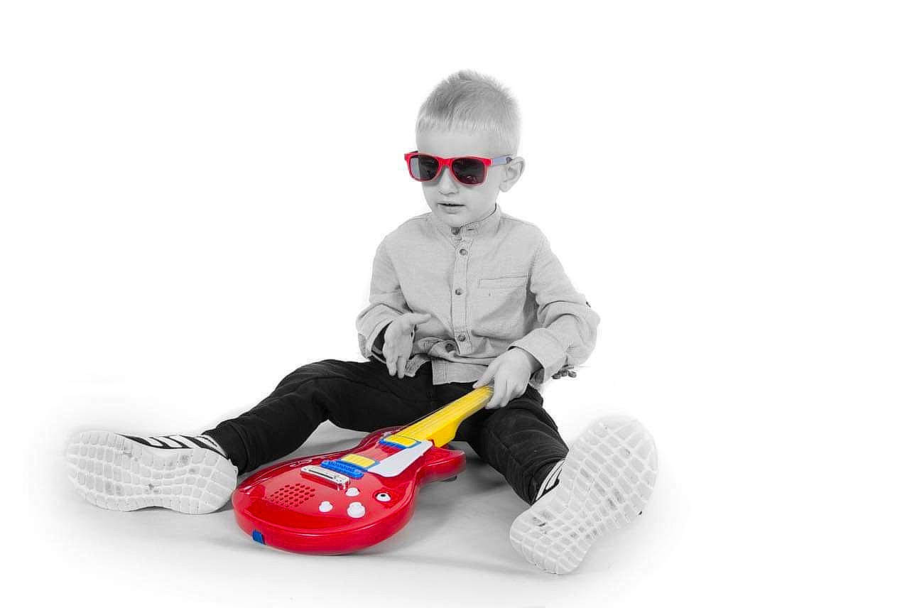 Sebastian is registered to the contest to win money with this photo: baby_products, baby_toddler_clothing, baby_toys, child, eyewear, fictional_character, flooring, font, goggles, happy, musical_instrument, person, play, product, recreation, sitting, sled, sleeve, string_instrument, sunglasses