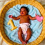 baby, infant, diaper, basket, blanket, blue_blanket, wicker, soft_texture, number_one, plush_toy, heart_emoji, cute, newborn, lying_down, indoor, skin, hand, foot, face, child