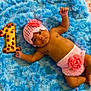 baby, infant, crochet, hat, diaper_cover, rose, blue_rug, cookie, number_one, chocolate_chips, lying_down, cute, celebration, milestone, soft_texture, hand_raised, barefoot, portrait, indoors, child