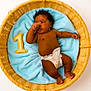 baby, infant, diaper, basket, blue_blanket, plush_number, number_one, thumb_sucking, cute, child, newborn, laying_down, soft_texture, woven_basket, milestone, portrait, skin, cute_baby, resting, cozy