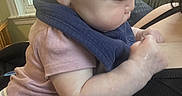 Dakota is registered to the contest to win money with this photo: baby, infant, child, pink_shirt, striped_pants, blue_scarf, indoor, window, adult, black_clothing, skin, face_profile, leaning, cuddling, person, closeup, home, light, daylight, cute