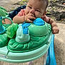 baby, child, walker, toy, outdoor, concrete, green, blue, person, infant, chewing, hand, play, sunlight, nature, grass, foot, clothing, face, cute