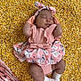 baby, infant, sleeping, pink_clothing, headband, corn_kernels, patterned_fabric, soft_lighting, cute, resting, child, outdoor_texture, small_hands, small_feet, gloves, socks, adorable, peaceful, portrait, closeup
