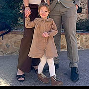 Luna a rejoint le concours — aidez-le/la à gagner de superbes lots ! child, toddler, girl, smile, holding_hands, dress, tights, boots, shoes, parents, adult_legs, sandals, suit_pants, stone_wall, pavement, backpack, greenery, outdoor, portrait, happy