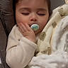 baby, sleeping, pacifier, blanket, teddy_bear_pattern, hand, infant, cozy, cute, soft_texture, peaceful, child, wrapped, resting, indoors, portrait, young_child, nap_time, warm, comfort