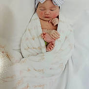 Nova Rios is registered to the contest to win money with this photo: adorable, baby, blanket, bow, child, cute, foot, hand, headband, indoors, infant, newborn, peaceful, person, portrait, resting, skin, sleeping, soft, wrapped