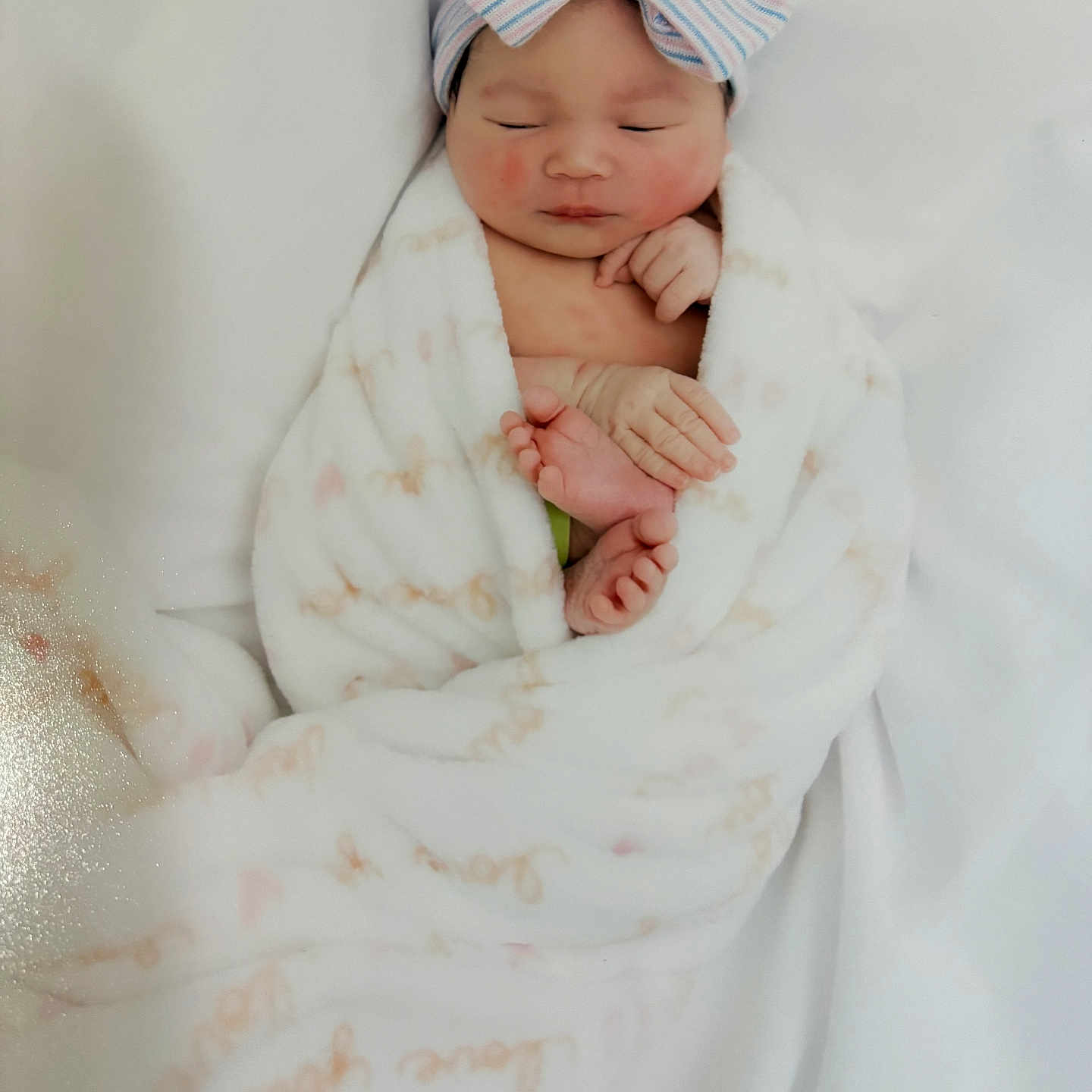 Nova Rios is registered to the contest to win money with this photo: newborn, baby, sleeping, blanket, bow_hat, infant, wrapped, soft_texture, peaceful, cute, hands, feet, white_background, cozy, portrait, child, toddler, headwear, resting, indoors