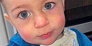 Kellyam a rejoint le concours — aidez-le/la à gagner de superbes lots ! toddler, child, face, blue_eyes, rosy_cheeks, blue_robe, clothing, portrait, indoors, cute, expression, young_child, person, head, skin, hair, eyelashes, nose, mouth, background