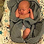 newborn, baby, sleeping, blanket, diaper, infant, baby_seat, patterned_fabric, cozy, soft, wrapped, peaceful, cute, resting, child, indoors, comfort, small, face, skin