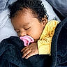 Leslie is registered to the contest to win money with this photo: baby, sleeping, pacifier, curly_hair, yellow_sweater, blanket, black_blanket, cozy, hand, face, infant, resting, closeup, indoors, soft_texture, child, peaceful, toddler, portrait, blanket_texture