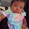 Leslie is registered to the contest to win money with this photo: baby, child, infant, pink_bow, pastel_dress, colorful_clothing, curly_hair, indoor, portrait, person, cute, closeup, holding, young_child, soft_lighting, expression, looking_at_camera, seated, fabric, human