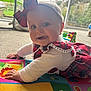 baby, child, crawling, play_mat, plaid, bow, headband, tongue_out, indoor, carpet, window, garden, cute, smiling, colorful, clothing, person, infant, happy, young_child