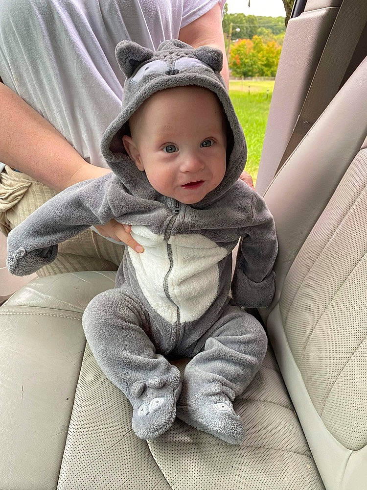 Andy is registered to the contest to win money with this photo: auto_part, baby, cap, car, car_seat, car_seat_cover, child, comfort, family_car, grass, happy, hat, headwear, person, plant, sitting, smile, steering_wheel, sun_hat, toddler