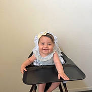 Esther joined the competition — help win amazing prizes! baby, high_chair, smiling, headband, bow, infant, child, furniture, indoor, carpet, wall, clothing, cute, happy, person, portrait, sitting, arm, hand, foot