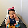 Esther joined the competition — help win amazing prizes! baby, child, high_chair, donuts, sprinkles, headband, blue_dress, stars, food, snack, table, crumbs, happy, indoor, celebration, cute, infant, person, eating, playful