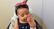 Esther joined the competition — help win amazing prizes! baby, blue_dress, celebration, child, cute, donuts, face, food, happy, headband, high_chair, indoor, messy, person, sitting, snack, sprinkles, sweet, table, treat