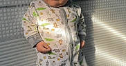 Mav is registered to the contest to win money with this photo: baby, infant, child, crib, pajamas, hat, gray_hat, animal_print, lying_down, wide_eyed, portrait, face, indoor, nursery, mattress, sunlight, shadows, sleepwear, cute, photograph