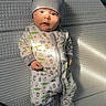 baby, infant, child, crib, pajamas, hat, gray_hat, animal_print, lying_down, wide_eyed, portrait, face, indoor, nursery, mattress, sunlight, shadows, sleepwear, cute, photograph