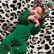 Xodi Rey joined the competition — help win amazing prizes! baby, infant, green_outfit, ruffles, bow, headwear, blanket, leopard_print, pattern, white_socks, cute, portrait, indoor, soft_texture, holiday_theme, christmas, child, person, resting, young