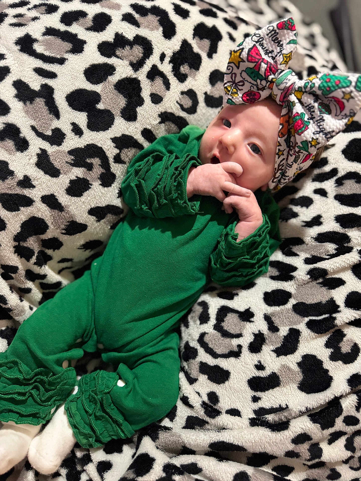 Xodi Rey joined the competition — help win amazing prizes! baby, infant, green_outfit, ruffles, bow, headwear, blanket, leopard_print, pattern, white_socks, cute, portrait, indoor, soft_texture, holiday_theme, christmas, child, person, resting, young