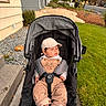 Maverick is registered to the contest to win money with this photo: baby, infant, child, stroller, outdoor, portrait, cap, hat, overalls, corduroy, clothing, harness, sitting, sleepy, face, house, yard, grass, autumn, neighborhood