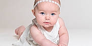 Chloe is registered to the contest to win money with this photo: baby, blue_eyes, child, crawling, cute, expression, face, girl, hands, headband, infant, innocence, lying_down, portrait, skin, soft_lighting, studio, white_background, white_dress, young