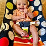 baby, child, smiling, happy, infant, sitting, polka_dot, colorful, seat, furniture, indoors, cute, young_child, person, face, skin, legs, feet, clothing, pattern