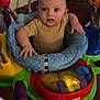baby, child, indoor, activity_jumper, toy, colorful, curious, infant, floor, playtime, expression, person, seat, clothing, face, hands, wooden_floor, home, smile, young