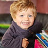 Ayden a rejoint le concours — aidez-le/la à gagner de superbes lots ! child, smiling, blue_eyes, blonde_hair, books, stack_of_books, indoors, portrait, happy, young_child, cozy, casual_clothing, long_sleeve, couch, close_up, face, person, bright, colorful, leaning