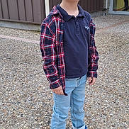 Ayden participe au concours pour gagner de l'argent avec cette photo : child, boy, blonde_hair, plaid_shirt, navy_polo, jeans, sneakers, outdoor, building, door, concrete_ground, casual_clothing, standing, young, person, daylight, sidewalk, fashion, looking_at_camera, urban