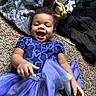 baby, child, smiling, blue_dress, tulle_skirt, carpet, indoor, happy, portrait, person, clothing, fabric, blanket, star_pattern, cute, infant, playful, toddler, lying_down, fun