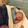 Nolan a rejoint le concours — aidez-le/la à gagner de superbes lots ! newborn, baby, sleeping, blanket, hospital, bassinet, infant, cozy, soft, cute, child, wrapped, peaceful, blue_clothing, wristband, indoors, portrait, resting, bed, young
