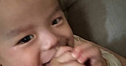 Luca is registered to the contest to win money with this photo: baby, infant, foot, hand, chewing, closeup, face, skin, cute, child, young, indoors, cozy, person, expression, curiosity, apparel, sleeve, head, comfort