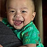 baby, child, smiling, happy, face, person, green_shirt, letters, closeup, portrait, expression, cute, indoor, holding, human, infant, joy, toddler, short_hair, skin