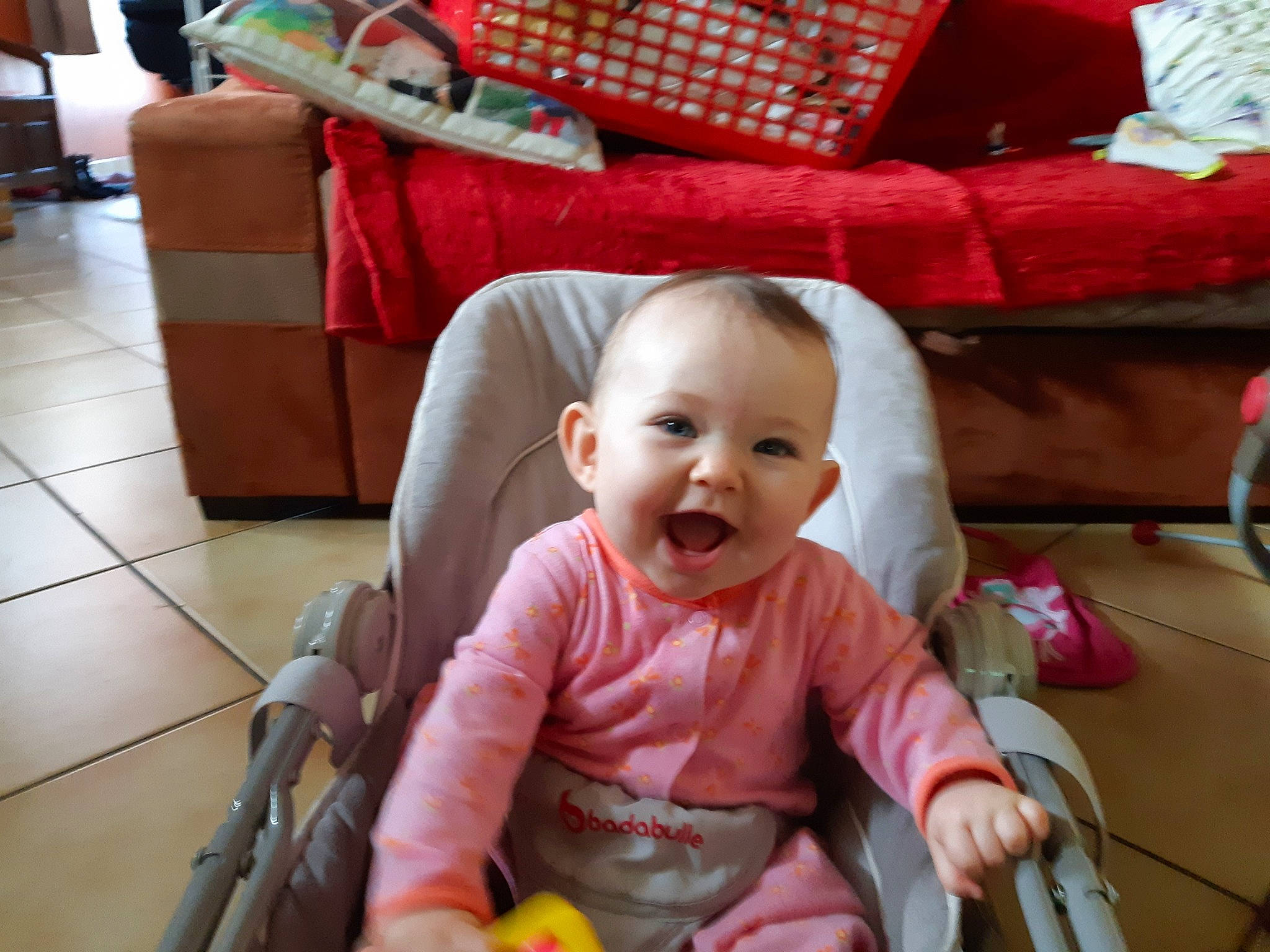 Emilie participe au concours pour gagner de l'argent avec cette photo : baby, baby_toddler_clothing, chair, cheek, child, comfort, couch, event, eye, flooring, fun, happy, lap, person, red, room, sitting, skin, smile, toddler