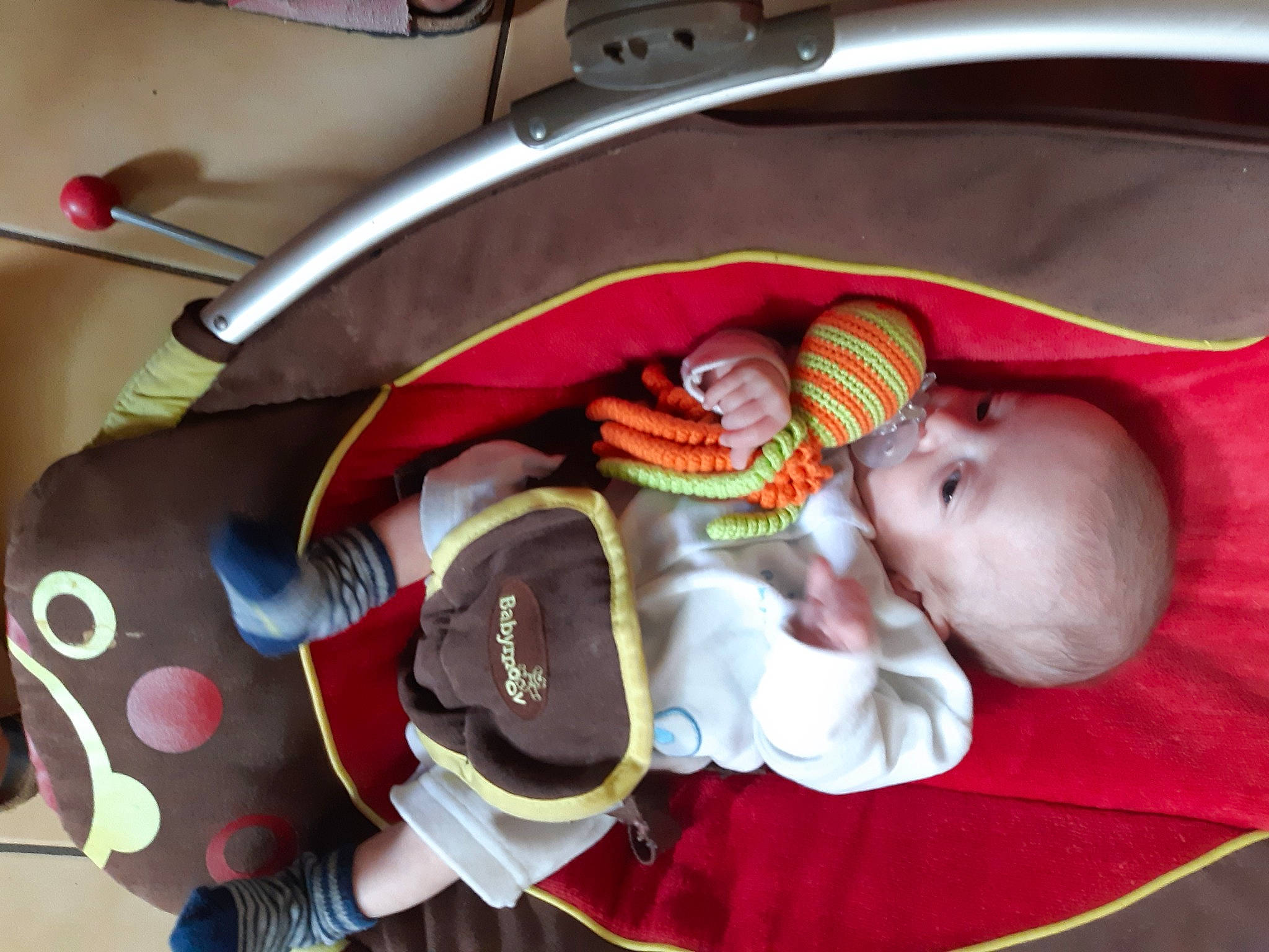 Hugo Et Baptiste a rejoint le concours — aidez-le/la à gagner de superbes lots ! auto_part, baby, baby_carriage, baby_products, baby_sleeping, baby_toddler_clothing, car_seat, carmine, child, comfort, infant_bed, linens, mouth, orange, person, personal_protective_equipment, room, steering_wheel, stuffed_toy, toddler